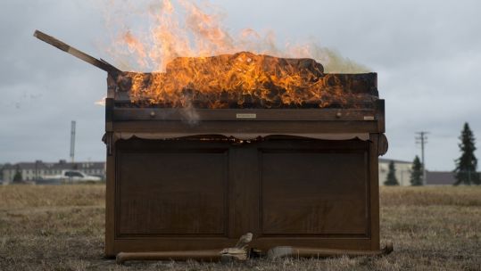 A piano is burned during US Air Force 3rd Wing’s 100th anniversary celebration