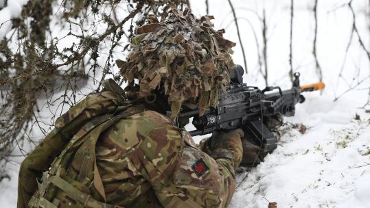 A soldier from 1st Battalion The Royal Welsh looks out from a snow covered trench during Exercise Winter Camp at a training area near Tapa in Estonia