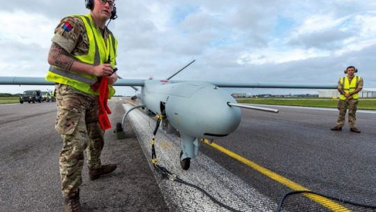 A soldier from 47 Regiment, Royal Artillery, removes safety warnings and covers from a Watchkeeper Unmanned Arial Vehicle at Lydd Airport, Kent