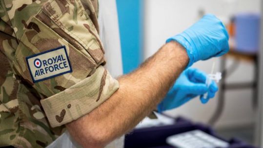 Cover image: RAF service member carries out coronavirus testing duties (Picture: MOD).