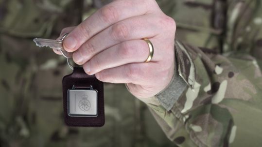 Anonymous military hand with wedding ring holding key CREDIT MOD