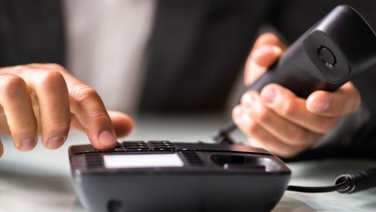Anonymous person making phone call on landline