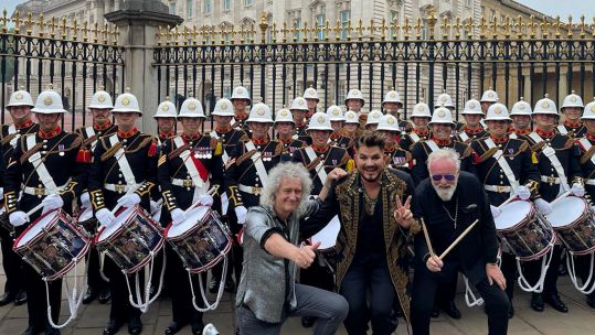 Bands of HM Royal Marines pose with singers Adam Lambert and Dr Brian May outside Buckingham Palace 040622 CREDIT RMBandService Twitter