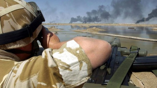 A British soldier observes the city of Basra from the far bank of the Shatal Basra Waterway.