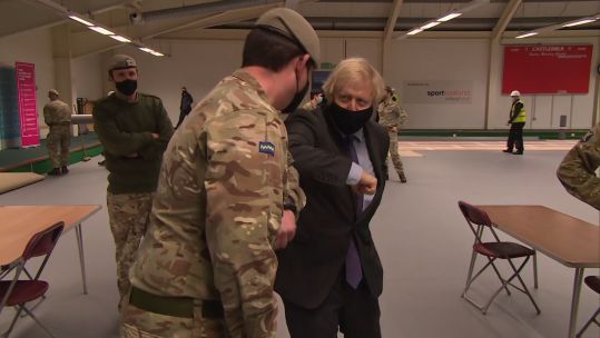 Boris Johnson bumping elbows with Army personnel setting up a vaccination centre in Scotland 