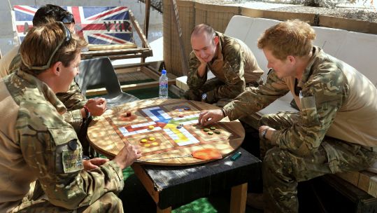 Britain's Prince Harry plays a game of Uckers with fellow pilots at Camp Bastion, southern Afghanistan 03112012 CREDIT ALAMY
