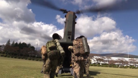 British and Japanese military personnel boarding a Chinook.