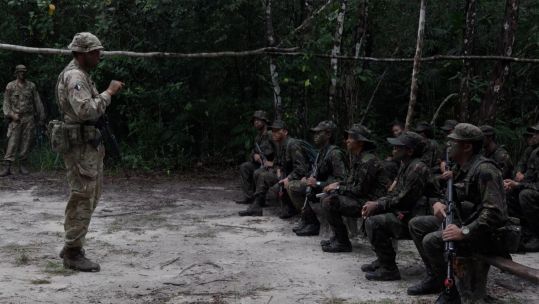 British soldier giving a lesson in the Belize forest to members of Belize Defence Force, Police and Coast Guard SEPTEMBER 2021