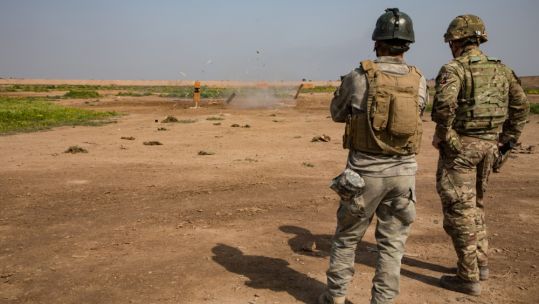 British soldier observes explosion with Iraqi soldier at Camp Taji