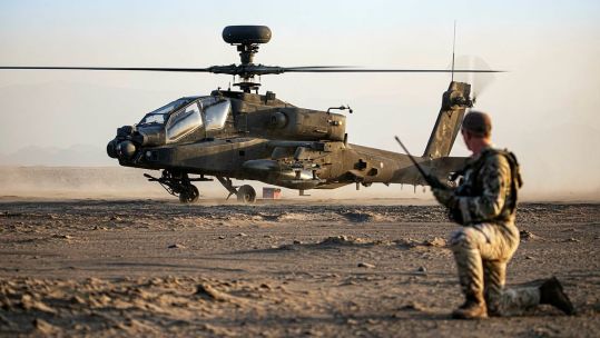 British soldier using a radio with an Apache (Picture: MOD).