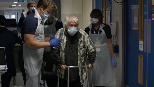 COVID patient Michael Kidd walks down the corridor of NHS Seacole.