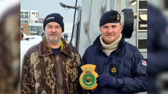 CPO Dave Earner presenting a Norwegian man with the crest of HMS Puncher
