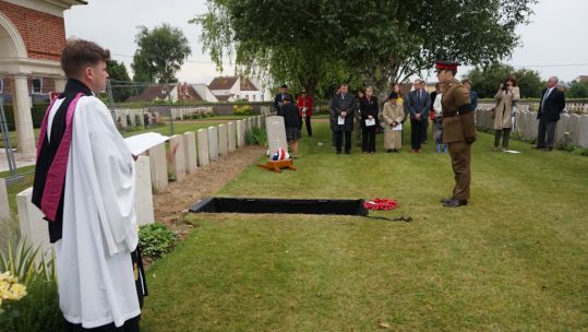 Capt David Hughes, lays a wreath at a graveside