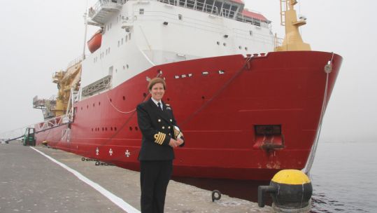 Captain Milly Ingham in front of HMS Protector