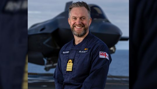 Captain of HMS Prince of Wales Captain Will Blackett standing in front of F-35 aircraft CREDIT Royal Navy.jpg 