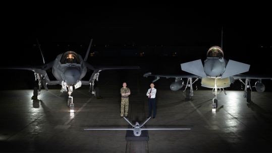 Chief of the Air Staff Air Chief Marshal Sir Rich Knighton and Defence Secretary John Healey stand behind a StormShroud drone with F-35B and Typhoon jets in the background