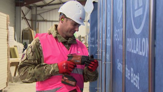 Soldier drills final screws into new single soldier’s accommodation unit.