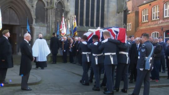 Coffin of WWII Bomb Aimer Jim Auton carried by RAF personnel.