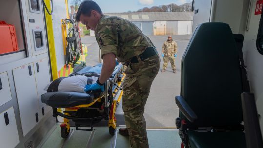 Coronavirus Welsh Ambulance Service - a member of Seven Brigade loads a stretcher onto an ambulance ready for use 060420 CREDIT MOD.jpg