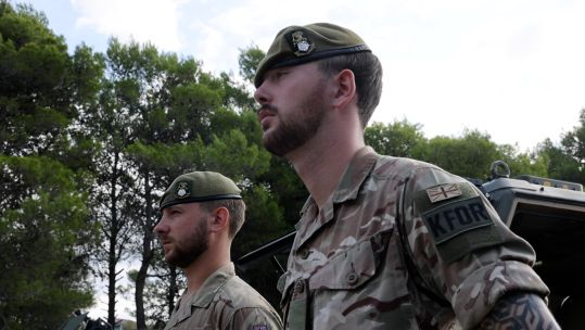 Soldiers standing in front of vehicles