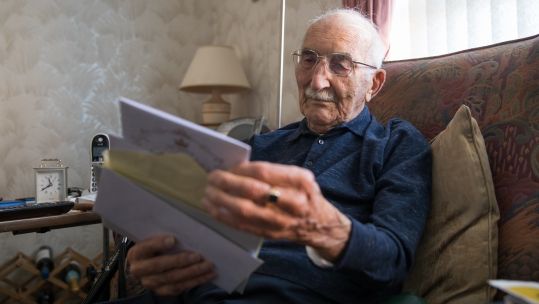 John Jenkins looks through birthday cards on his 100th birthday (Picture: PA).