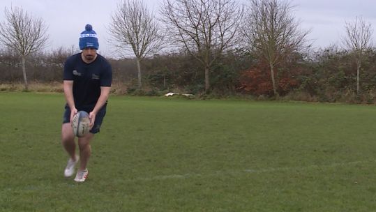 Cover image: With a rugby ball in hand, Craig practises his kicking technique.
