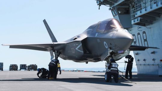 An F-35B fighter jet being fastened on aircraft carrier HMS Queen Elizabeth for Carrier Sea Training (Picture: Royal Navy).