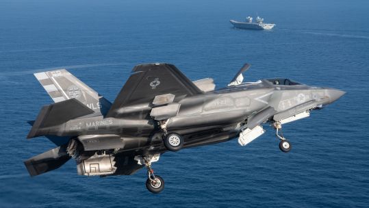 F-35B seen in foreground with HMS Prince of Wales behind as part of sea trials off US east coast (Picture: US Dept of Defense).