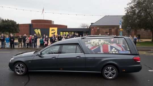 Cover Image: More than 100 people watched the funeral procession (Picture: PA).