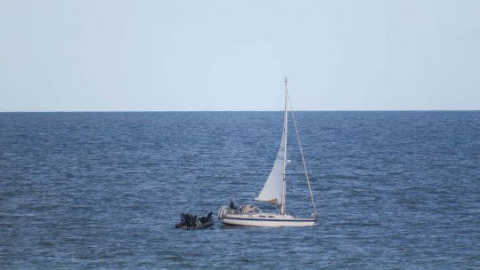 HMS Dragon personnel assist the stranded yacht (Picture: Royal Navy).