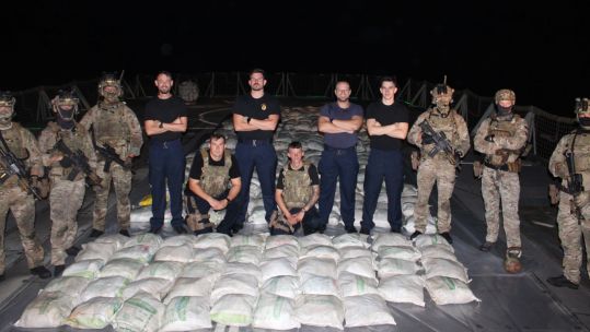 HMS Lancaster's sailors and Royal Marines pose with the haul of hashish after a seizure in the Arabian Sea