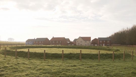 Housing built on Salisbury Plain as part of the Army Basing Programme, with a preserved henge
