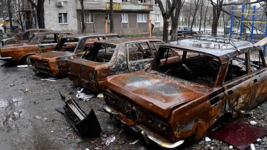 Broken and burned cars in a parking lot near a residential building in Mariupol (Picture: Anatoliy Zhdanov/Kommersant/Sipa USA/Alamy Stock Photo).