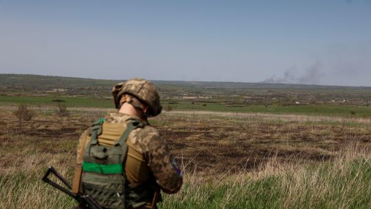 A Ukrainian serviceman looks on after a shelling in the Luhansk region of Ukraine