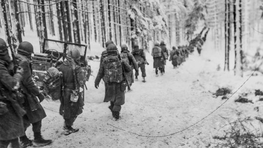 Image ID 2J2EW77 US infantry soldiers march along the snow-covered road on their way to cut off the Saint Vith-Houffalize road in Belgium during the Battle of The Bulge NO REUSE CREDIT Shawshots / Alamy Stock Photo
