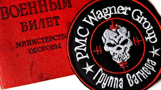 View of a logo of the Russian private military company Wagner Group and Russian military ID on white background 