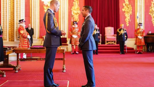 Group Captain Kevin Latchman, Royal Air Force, is decorated with the Air Force Cross by the Prince of Wales at Buckingham Palace