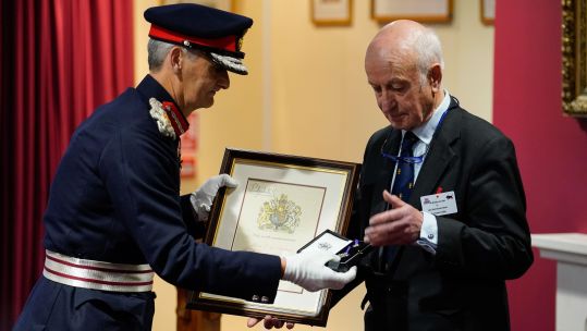 Nigel Atkinson, the Lord Lieutenant of Hampshire (left) presents Andrew Gillett, Major Edwin Andrews' nephew, with the Elizabeth Cross