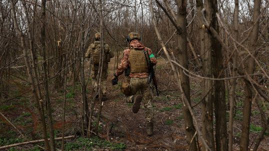 Image ID 2PK330K Ukrainian service members run between positions at the frontline, region of Bakhmut 05042023 CREDIT Reuters, Alamy EXP 12042024.jpg