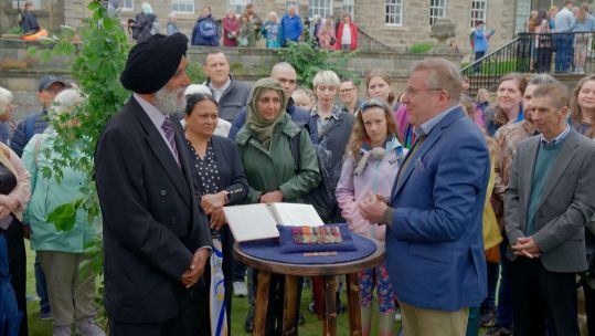 Expert Mark Smith speaks with Mr Singh the son of a Victoria Cross recipient at the Antiques Roadshow Episode Pollock Park 1 CREDIT BBC Studios