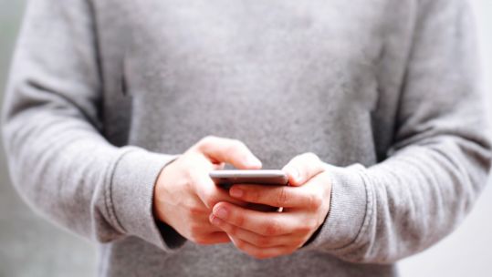 Anonymous hands using mobile phone