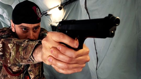 An Italian close protection soldier adopts a shooting stance with his Beretta 92FS