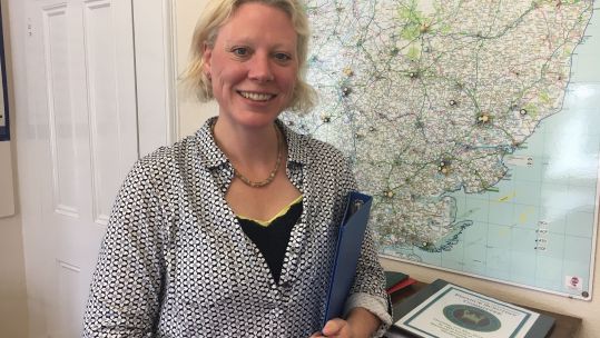 Smiling Jane Wilkes in her office