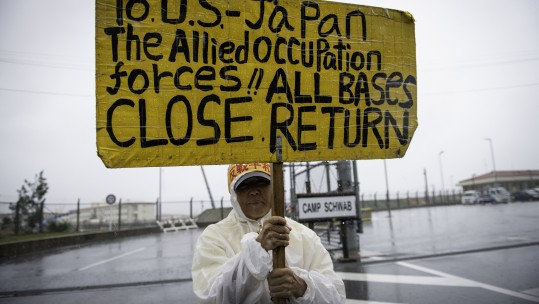 Japanese protester displays sign against a planned U.S military base relocation in Okinawa 