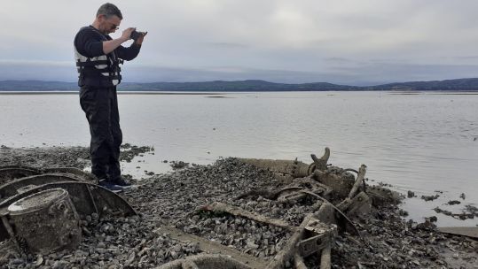 Jonny McNee, DAERA Marine Plan team, photographing the rotor and rotor blades of the discovered Royal Navy Dragonfly helicopter