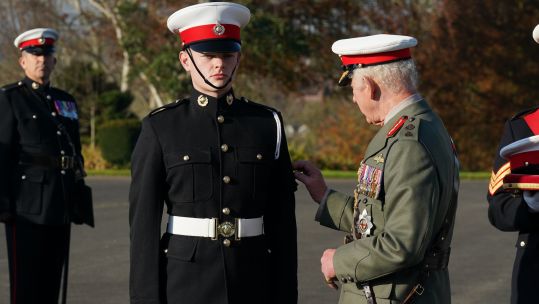 King presents Marine Osian Stephens with the King's Badge 