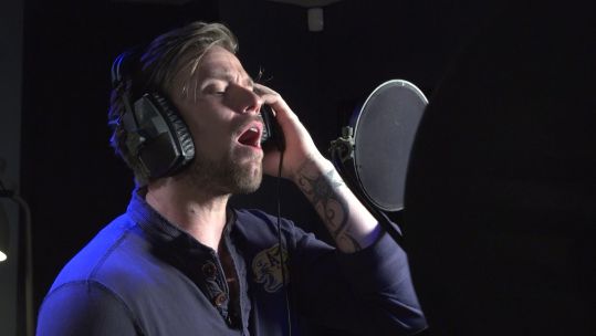 Lance Corporal Liam Wakefield singing into a microphone in a recording studio as he pursues a career in music following a medical discharge from the Army 