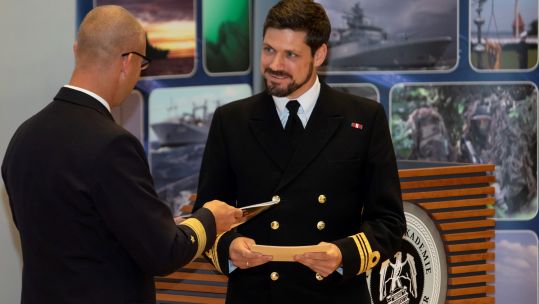 Cover image: Lieutenant Commander David Roberts (right) receives the top naval student award from the Commander of the German Navy's Baltic Forces (Picture: Royal Navy).