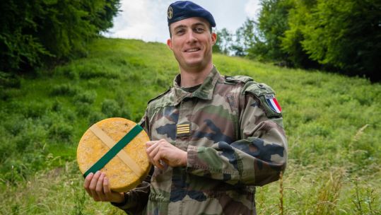Major Emmanuel of the armée de Terre with the Double Gloucester cheese (Picture: NATO ARRC).