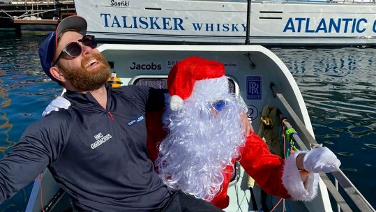 Member of HMS Oardacious with a Santa Claus suit 